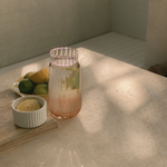 Glass of amber drink with lemon and lime on a stone surface