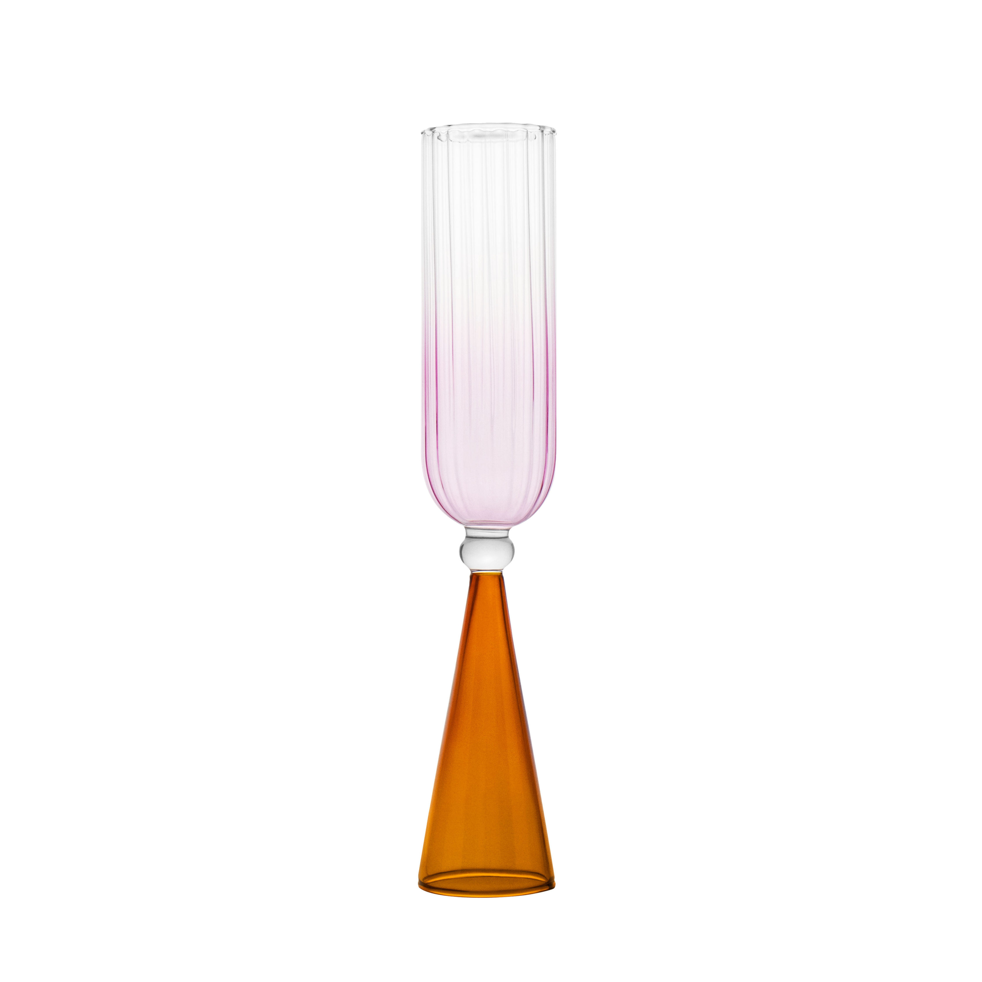 A single bespoke & handblown borosilicate champagne glass with gradient rose pink color, curved edged rim. Amber reddish-coloured stand on a white background. Designed for stemware use.